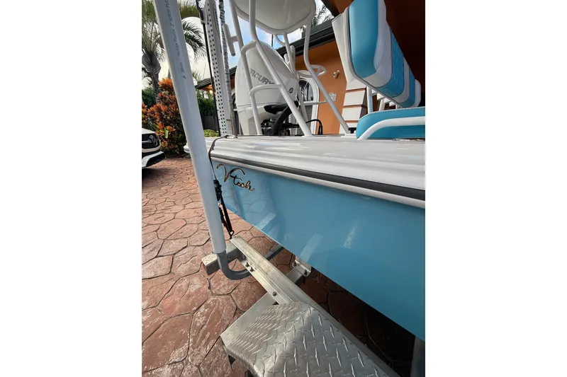 Slide: The Image of Blue V-Tech 18 boat, 2025 model, parked on a textured driveway. - 9