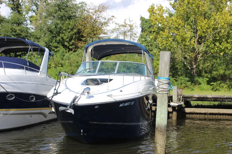 The Image of 2012 Sea Ray Sundancer 280 docked, surrounded by lush greenery and calm waters. - 1