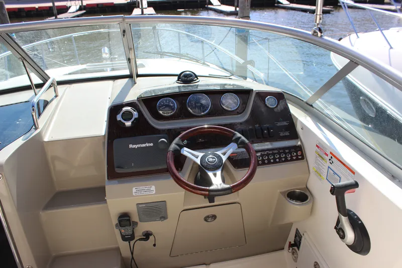 Slide: The Image of Cockpit of 2012 Sea Ray Sundancer 280 with steering wheel and control panel. - 13