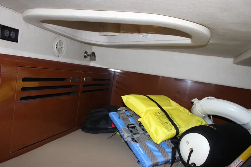 Slide: The Image of Interior cabin of 2012 Sea Ray Sundancer 280 with life jackets and storage. - 34
