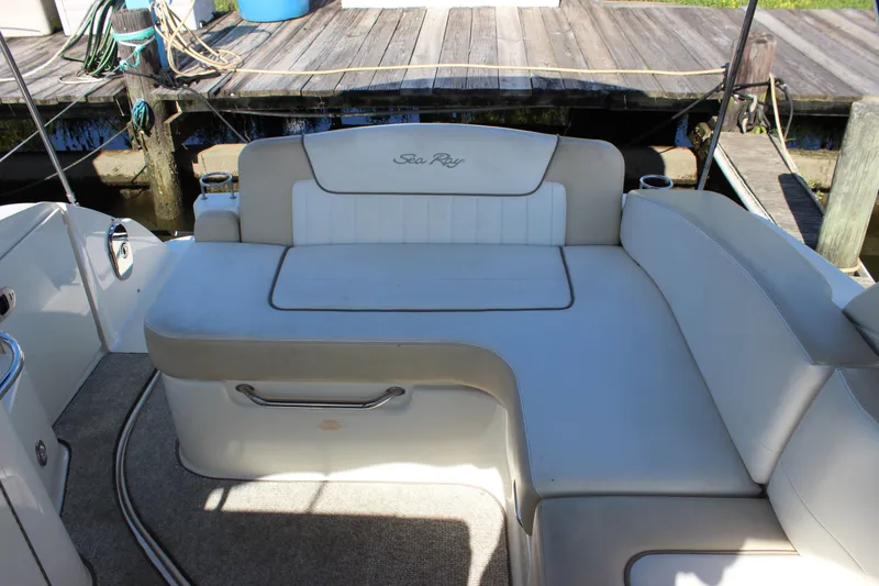 Slide: The Image of 2012 Sea Ray Sundancer 280 boat interior with white seating and dock background. - 15