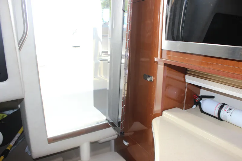 Slide: The Image of Interior view of 2012 Sea Ray Sundancer 280, featuring a kitchenette and safety equipment. - 32