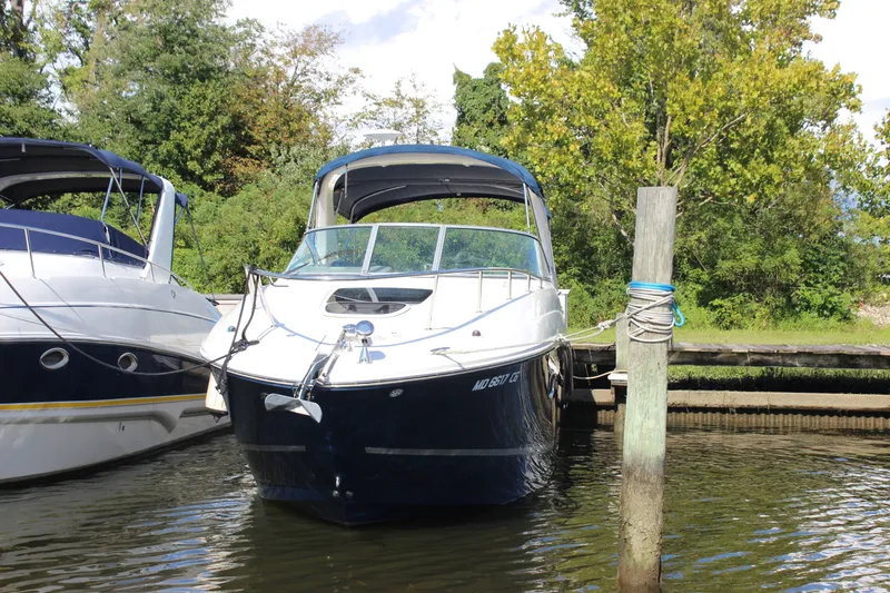 Slide: The Image of 2012 Sea Ray Sundancer 280 docked, surrounded by lush greenery and calm waters. - 2