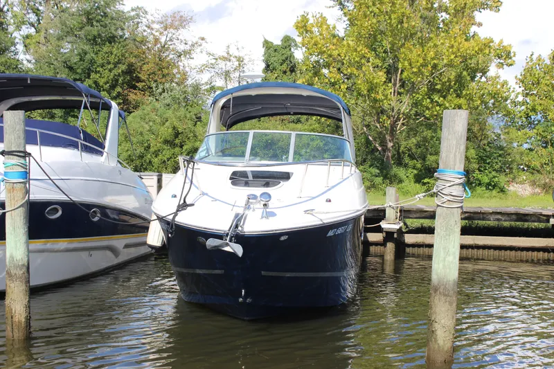 Slide: The Image of 2012 Sea Ray Sundancer 280 docked between pilings, surrounded by lush greenery. - 3