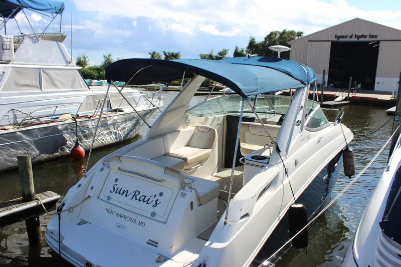 Slide: The Image of 2012 Sea Ray Sundancer 280 docked, featuring a blue canopy and spacious seating. - 10