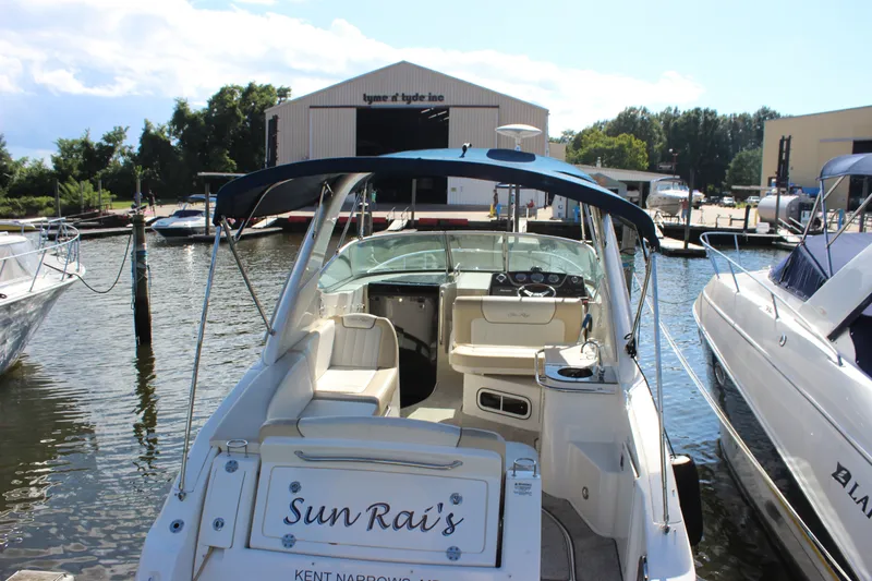 Slide: The Image of 2012 Sea Ray Sundancer 280 docked at marina, featuring spacious cockpit and blue canopy. - 9