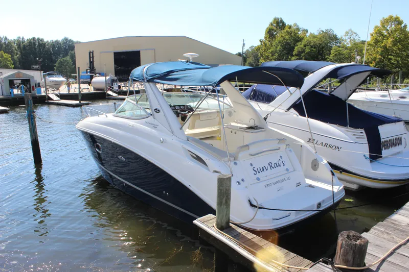 Slide: The Image of 2012 Sea Ray Sundancer 280 docked at marina, featuring sleek design and blue canopy. - 6