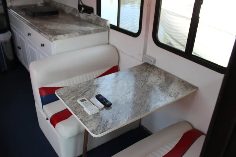 Slide: The Image of Interior of 1994 Sun Tracker Party Cruiser with dining area and marble-style table. - 14