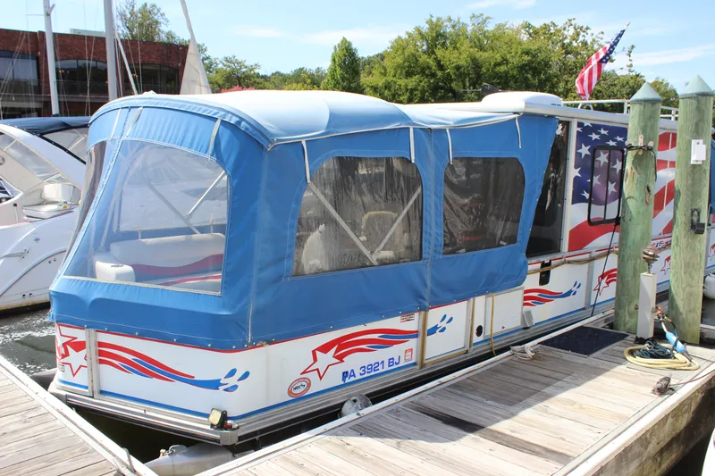 The Image of 1994 Sun Tracker Party Cruiser 32 Regency Edition docked with patriotic design and blue canopy. - 1
