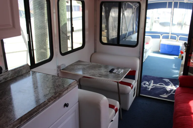 Slide: The Image of Interior of 1994 Sun Tracker Party Cruiser 32 with seating, table, and nautical decor. - 17