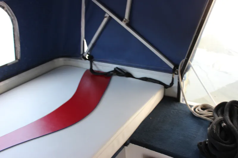 Slide: The Image of Interior of 1994 Sun Tracker Party Cruiser 32 with blue canopy and white seating. - 21