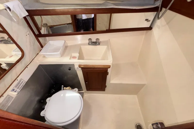 Slide: The Image of 1989 Bayliner 3288 Motoryacht bathroom with sink, toilet, and wooden cabinetry. - 15