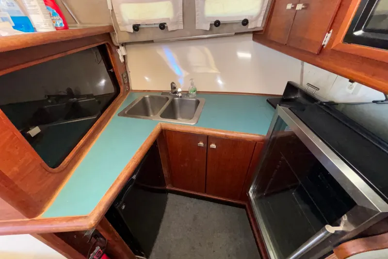 Slide: The Image of 1989 Bayliner 3288 Motoryacht kitchen with dual sinks, stove, and wooden cabinetry. - 14