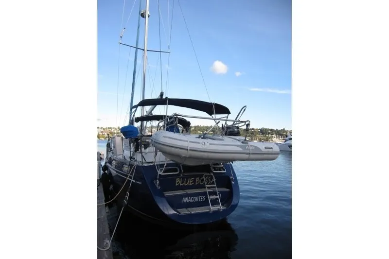 Slide: The Image of 2002 Nauticat 37 sailboat docked with inflatable dinghy, clear sky background. - 39