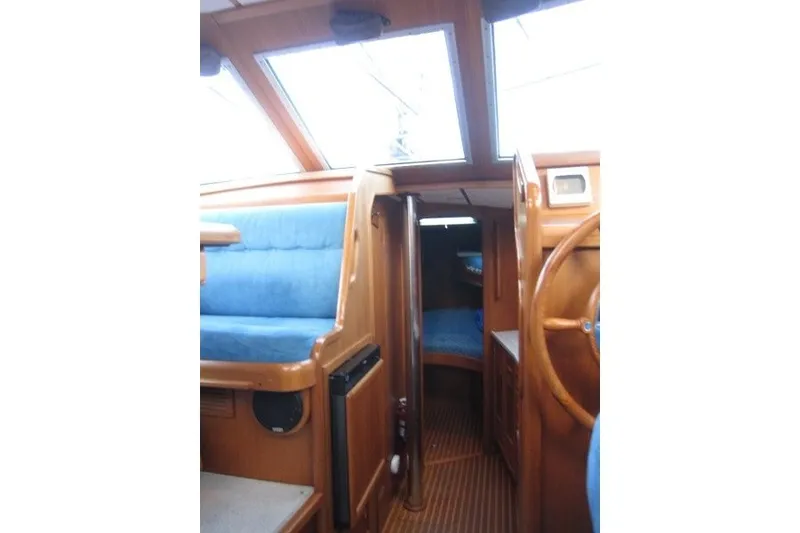 Slide: The Image of Interior of 2002 Nauticat 37 sailboat with wooden finish and blue seating. - 13