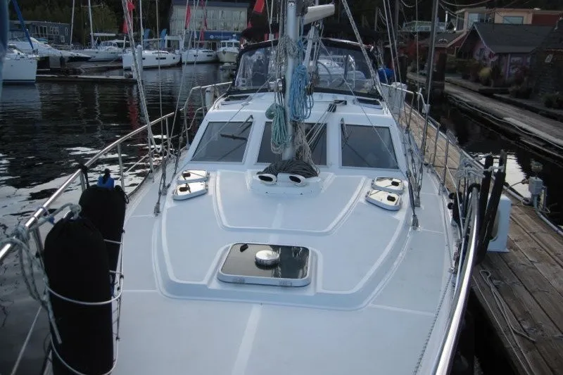 Slide: The Image of 2002 Nauticat 37 sailboat docked at a marina, showcasing its deck and rigging. - 34