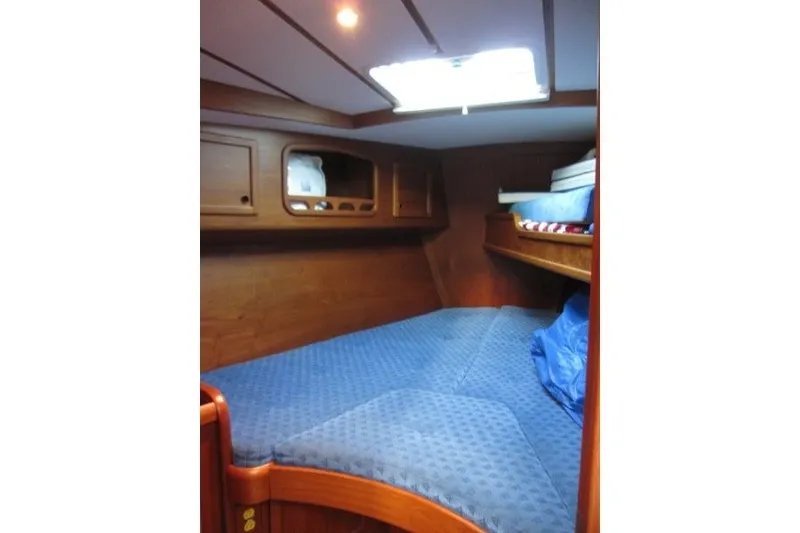 Slide: The Image of Cozy cabin interior of 2002 Nauticat 37 sailboat with blue bedding and wooden finish. - 15