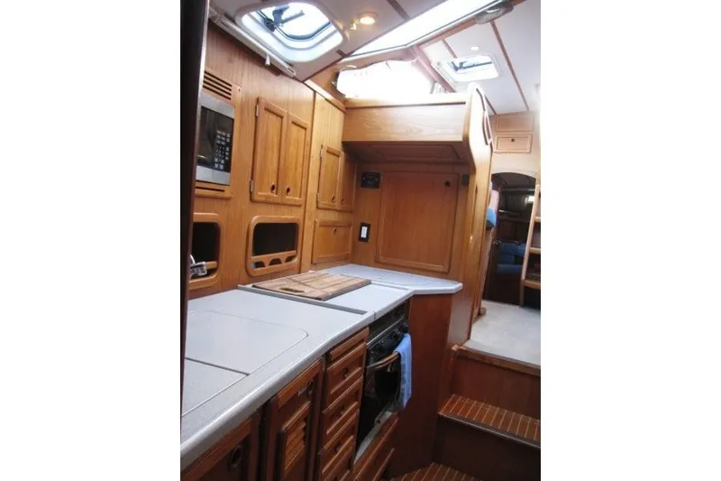 Slide: The Image of Interior of 2002 Nauticat 37 sailboat featuring a wooden galley with modern amenities. - 17