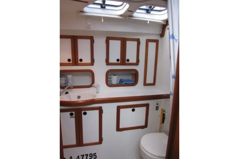 Slide: The Image of Nauticat 37 (2002) yacht bathroom with wooden cabinets and skylight. - 18