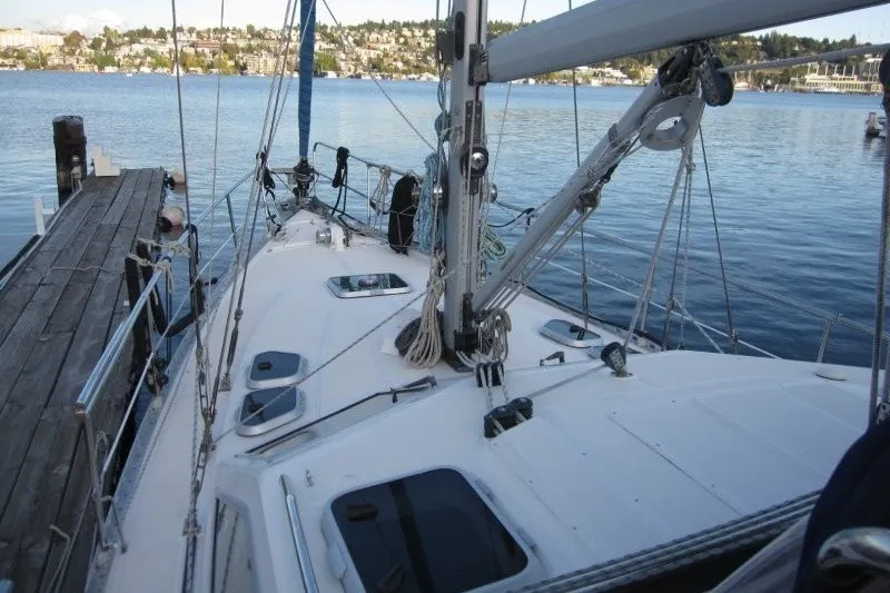 Slide: The Image of 2002 Nauticat 37 sailboat docked on calm waters with scenic background. - 31