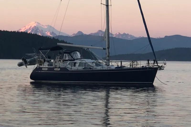Slide: The Image of Sailboat Nauticat 37 (2002) on calm water with mountain backdrop at sunset. - 1