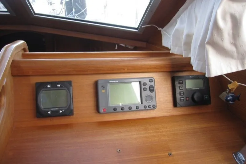 Slide: The Image of Nauticat 37 (2002) yacht dashboard with navigation instruments and wooden paneling. - 21