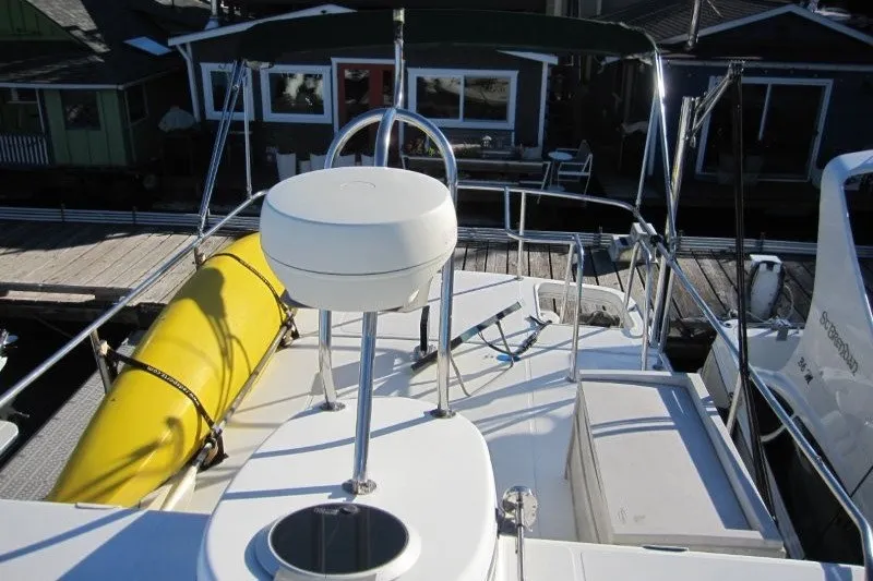 Slide: The Image of 2002 American Tug 34 boat deck with yellow kayak and marina view. - 31