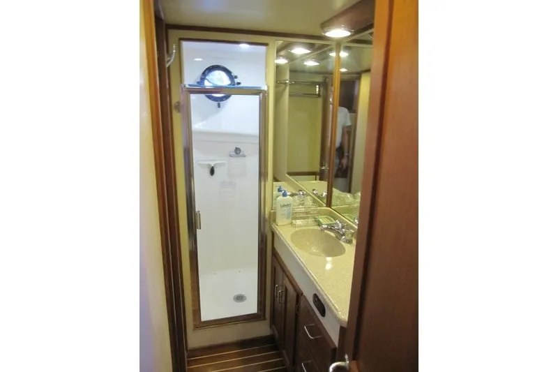 Slide: The Image of Bathroom interior of 2002 American Tug 34, featuring shower and sink with wooden cabinetry. - 13