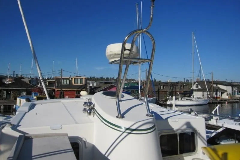Slide: The Image of American Tug 34 (2002) on deck, marina background, clear blue sky. - 29