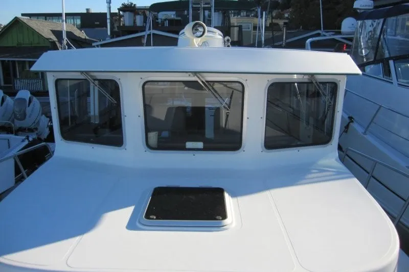 Slide: The Image of 2002 American Tug 34 boat with white cabin and large windows. - 36