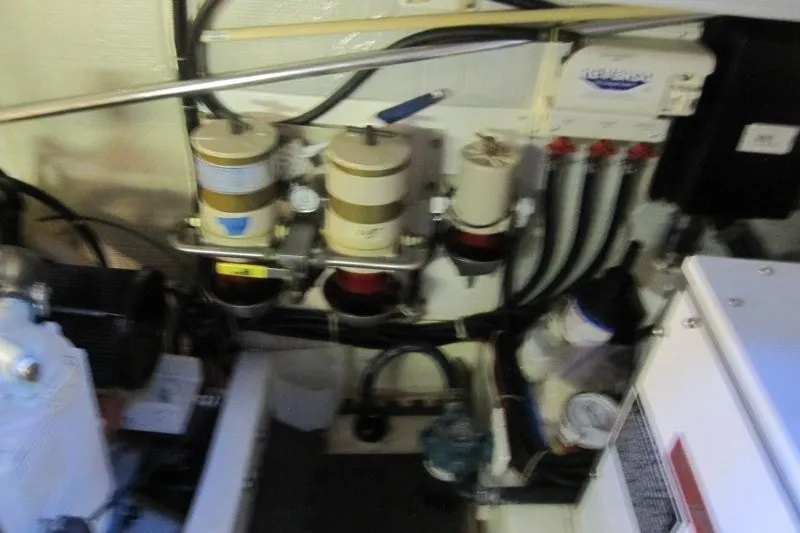 Slide: The Image of Engine room of a 2002 American Tug 34, featuring fuel filters and electrical components. - 22