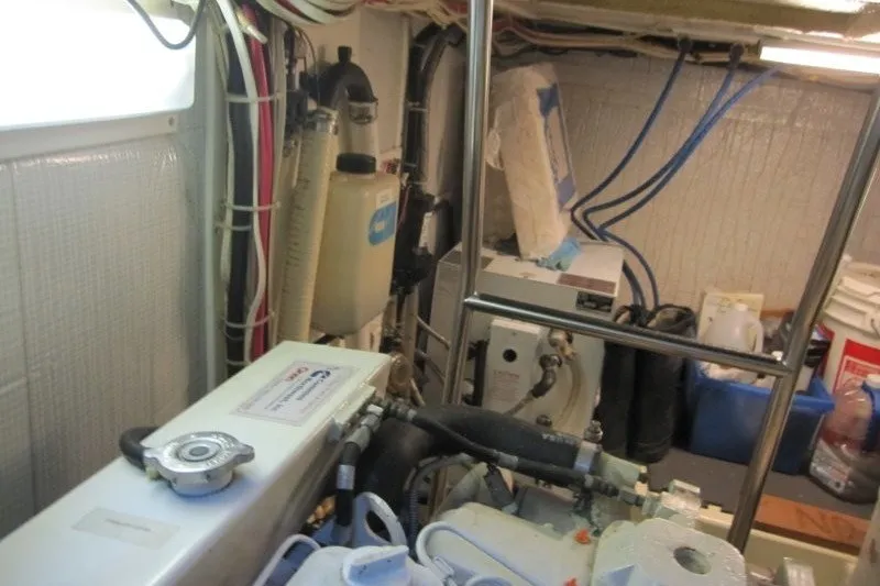 Slide: The Image of Engine room of a 2002 American Tug 34, showcasing mechanical components and wiring. - 24