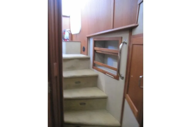 Slide: The Image of Interior stairs of a 2002 American Tug 34, featuring wooden accents and handrails. - 16