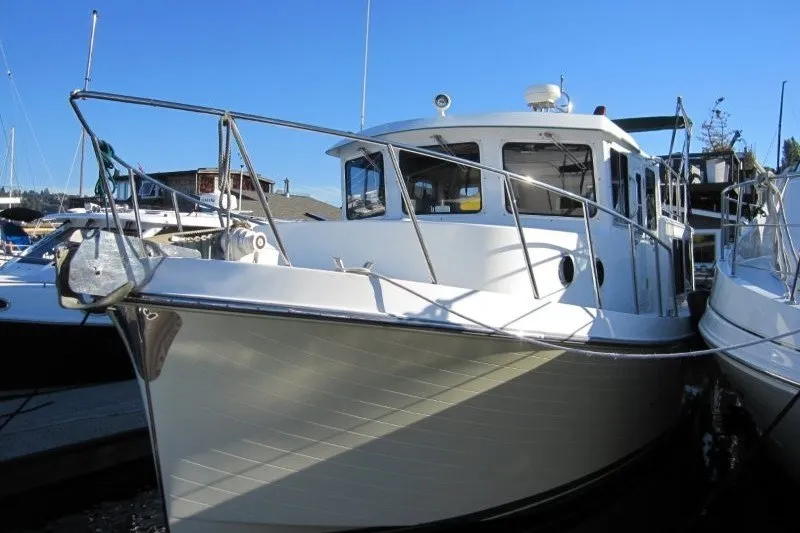 Slide: The Image of 2002 American Tug 34 docked at marina under clear blue sky. - 27