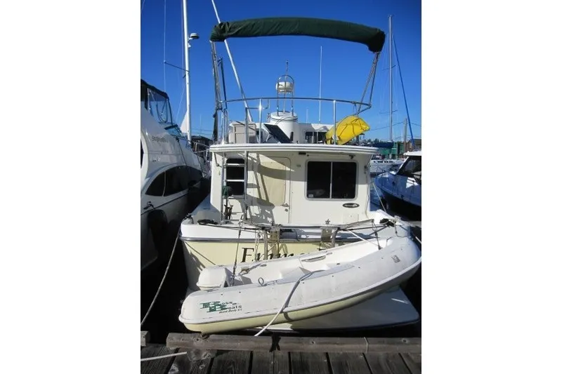 Slide: The Image of American Tug 34, 2002 model, docked with inflatable boat on stern. - 26