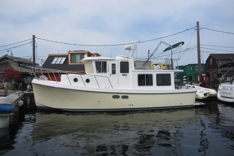 The Image of 2002 American Tug 34 docked at a marina, showcasing classic design and sturdy build. - 1