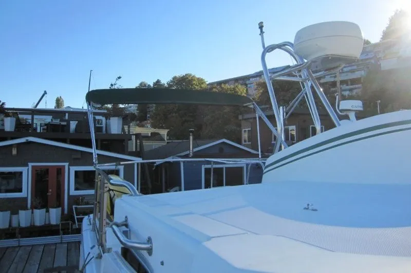 Slide: The Image of 2002 American Tug 34 docked near waterfront homes under clear blue sky. - 37