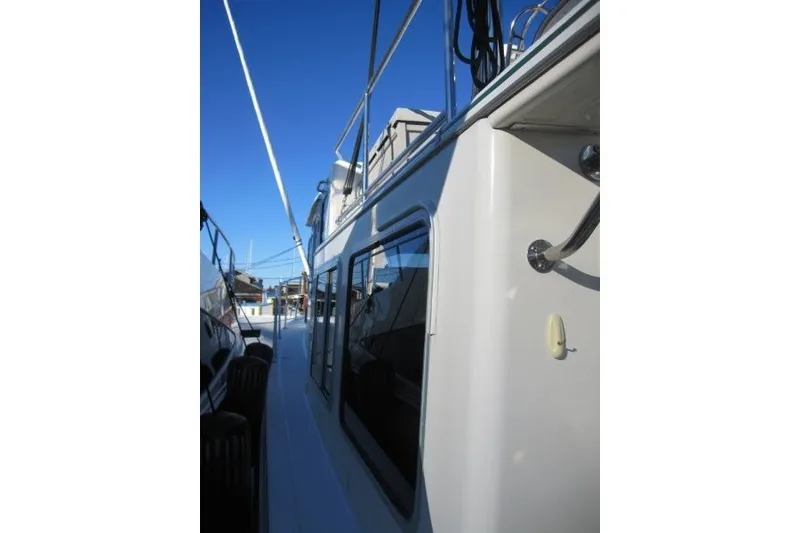 Slide: The Image of Side view of a 2002 American Tug 34 boat under clear blue skies. - 33