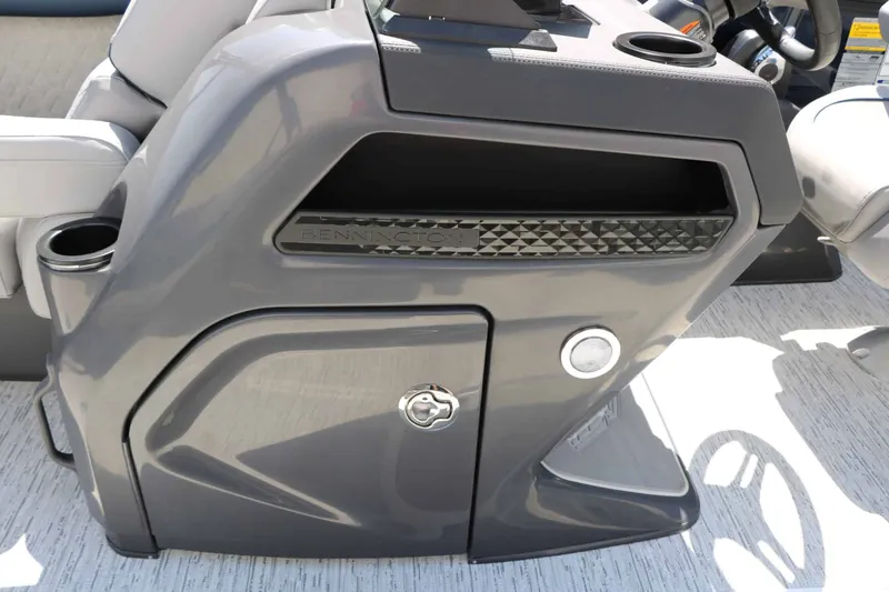 Slide: The Image of The image shows the gray dashboard of a Bennington 22 MSB Tri Toon boat with cup holders. - 38