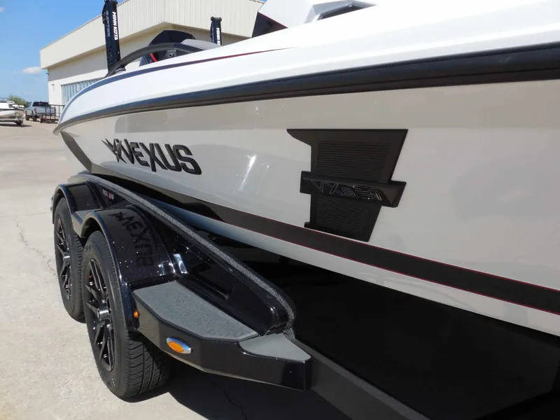 Slide: The Image of A 2027 Vexus VXs21 boat on a trailer, featuring a sleek black wheel and modern design. - 9