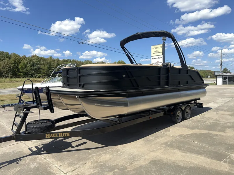 Slide: The Image of A 2027 Evotti 525 CS pontoon boat on a trailer in a parking lot. - 2