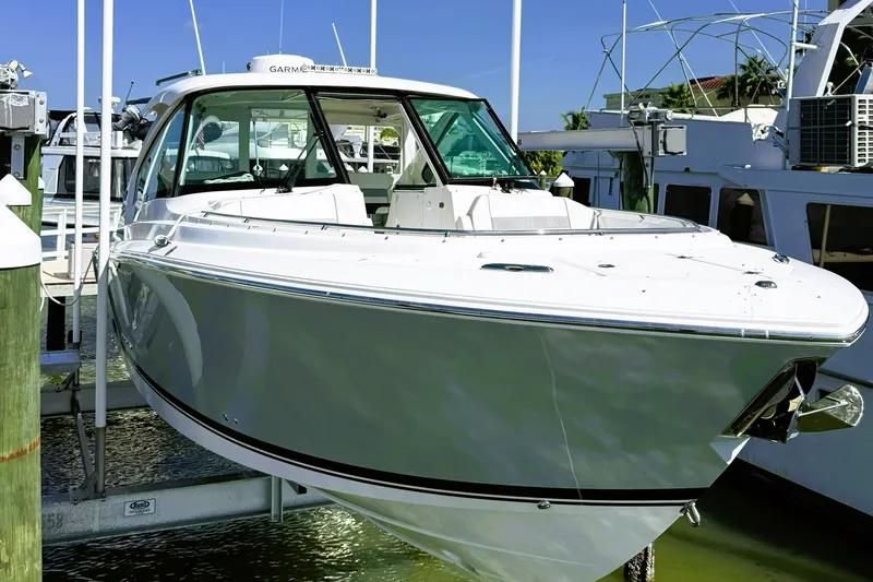 The Image of 2023 Pursuit D 326 boat docked at marina, showcasing sleek design and modern features. - 2
