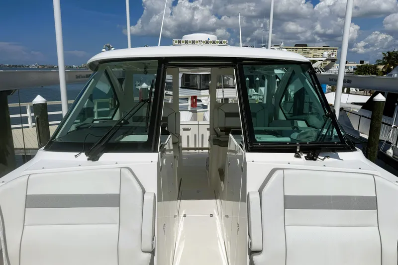 Slide: The Image of 2023 Pursuit D 326 boat docked at marina under clear blue sky. - 17