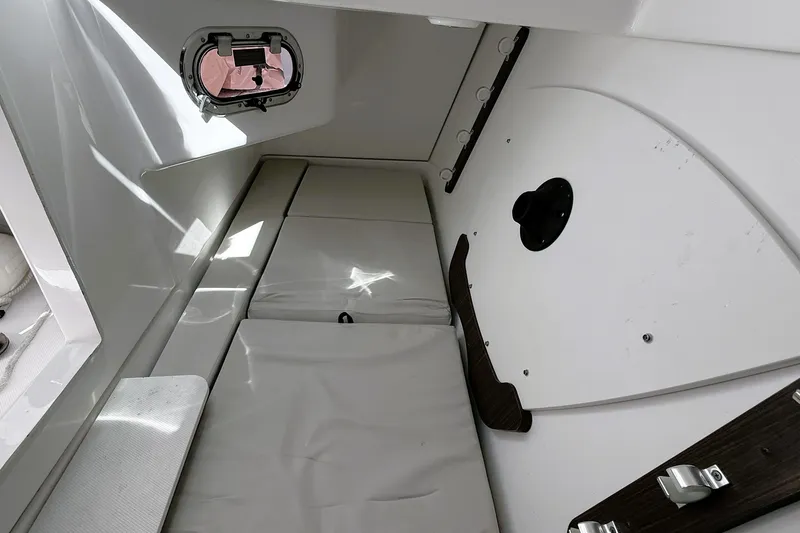 Slide: The Image of Interior cabin of 2023 Pusuit d 326 boat with cushioned seating and porthole. - 14