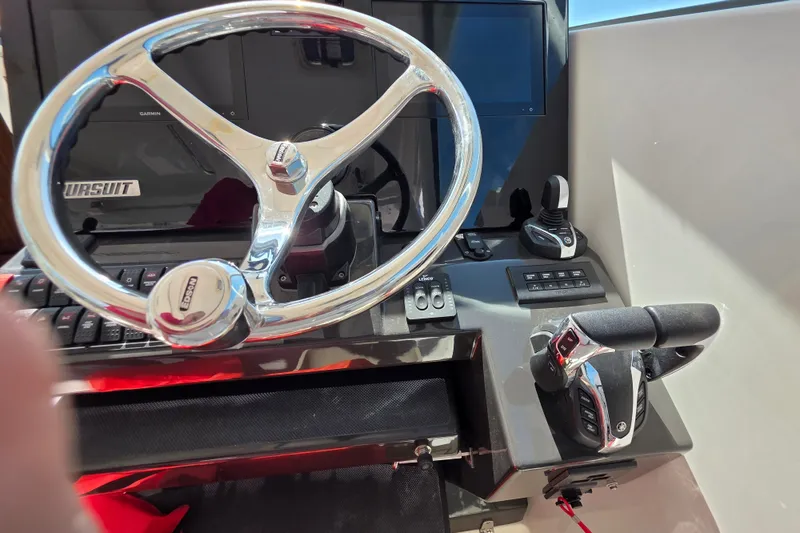 Slide: The Image of Steering wheel and controls of a 2023 Pursuit D 326 boat cockpit. - 11