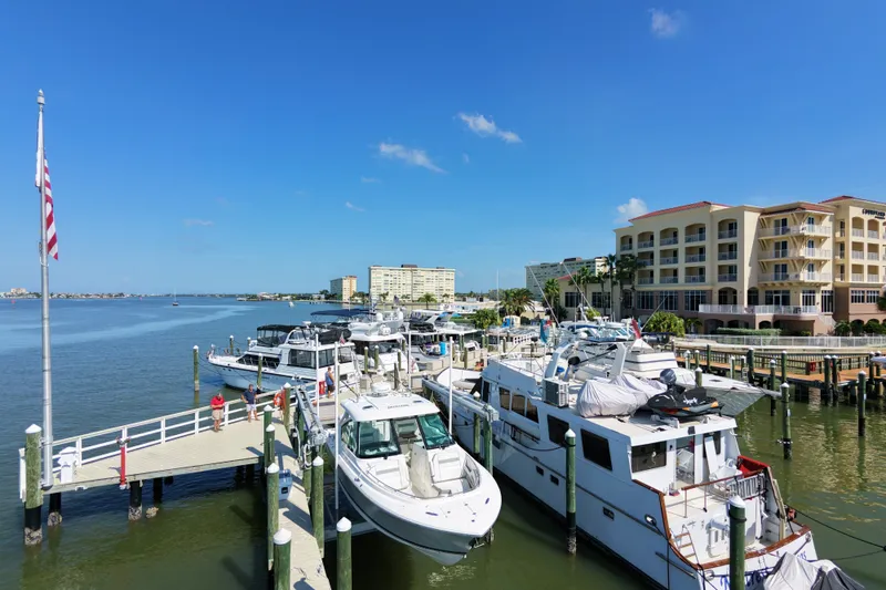 Slide: The Image of Boats docked at a marina with a 2023 Pursuit DC 326, under a clear blue sky. - 24