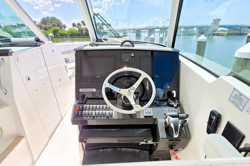 Slide: The Image of Helm of 2023 Pursuit D 326 boat with steering wheel and control panel. - 10