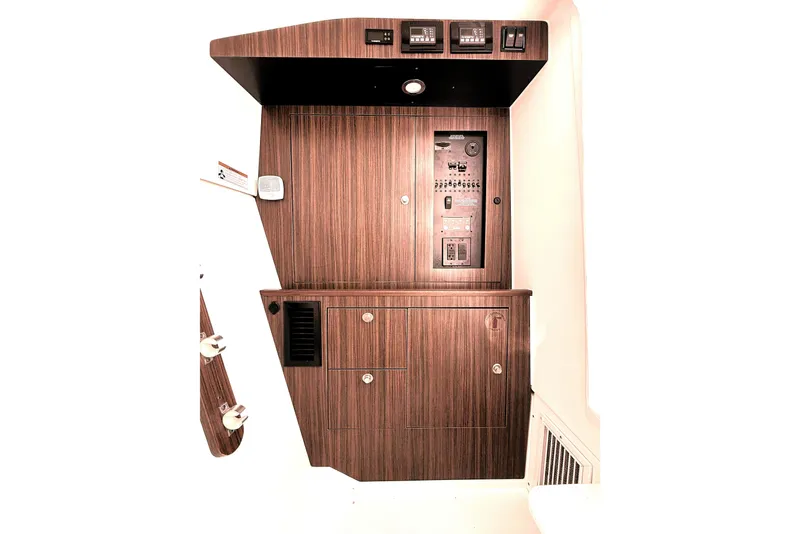 Slide: The Image of 2023 Pursuit DC 326 boat interior with wood paneling and control panel. - 15
