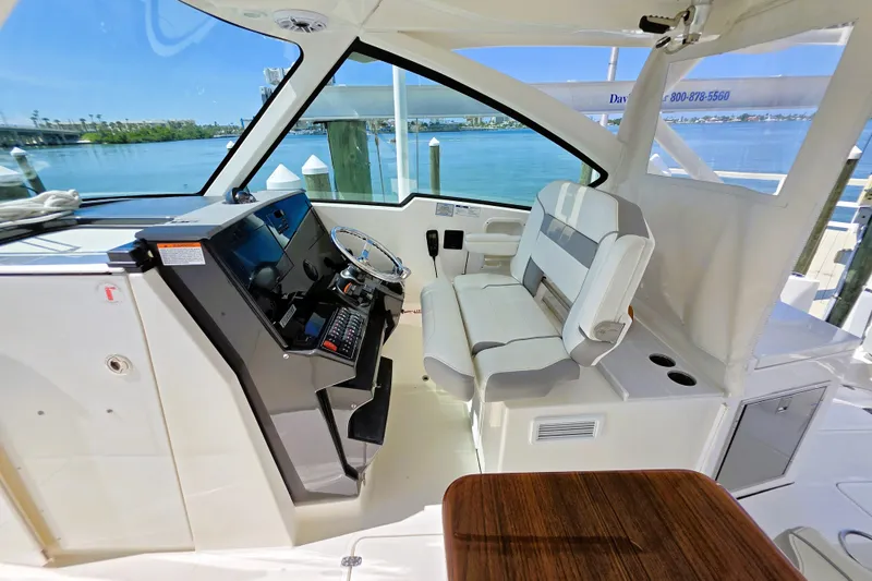 Slide: The Image of Interior of 2023 Pursuit D 326 boat with helm, seating, and waterfront view. - 9