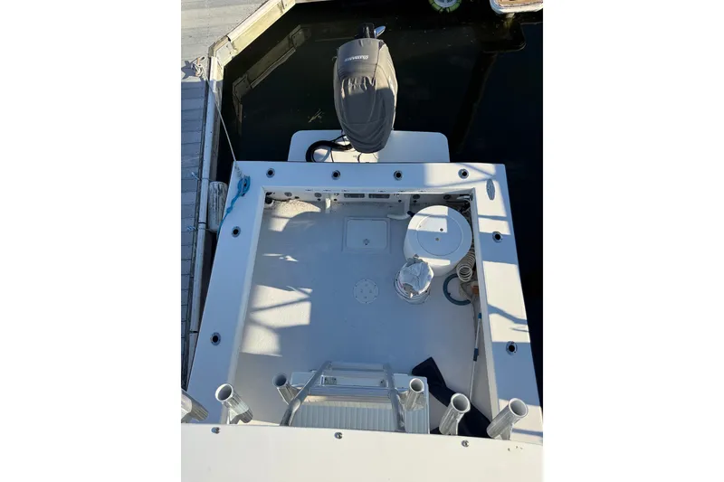 Slide: The Image of 2015 C-Hawk 25 Center Console boat docked, featuring spacious deck and outboard motor. - 11